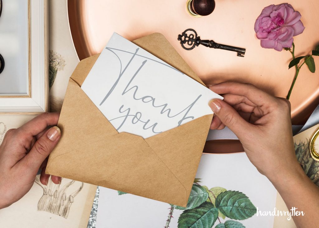 hands opening a thank you card